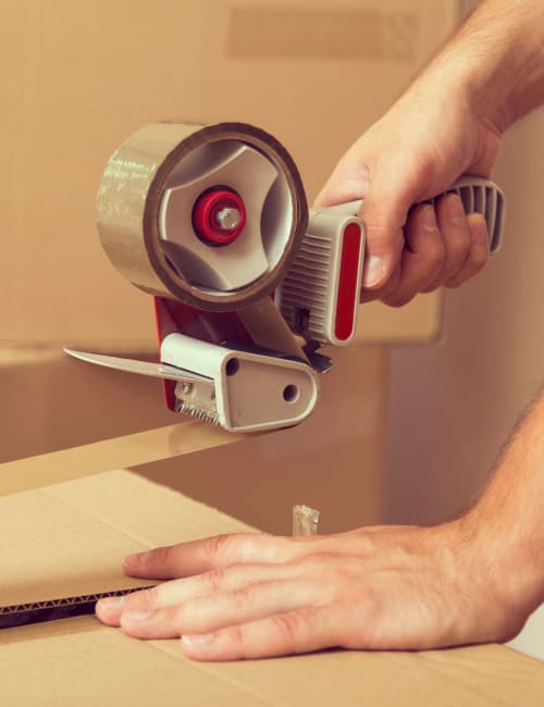 A man uses a tape dispenser to safely seal a box, which he'll store at Storage World in Sinking Spring, Pennsylvania