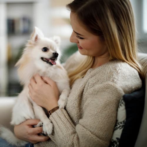 Happy resident and her pup in their new home at Olympus on Broadway in Carrollton, Texas
