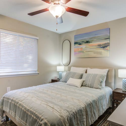 A furnished bedroom with a blue accent wall at The Point at Beaufont in Richmond, Virginia