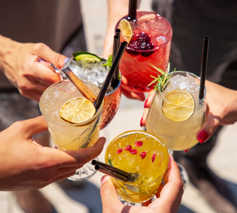 Five people holding their drinks together near Regency Gates in Mobile, Alabama