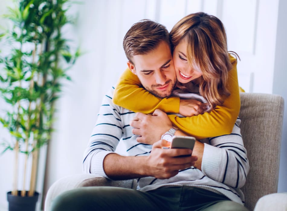 Residents holding each other while looking at their phone at Sofi Belmar in Lakewood, Colorado