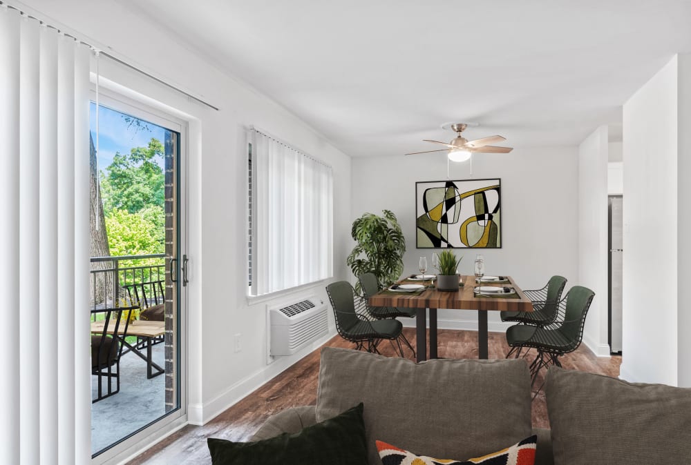 Dinign and living area leading out to a patio at Timberlake Apartment Homes in East Norriton, Pennsylvania