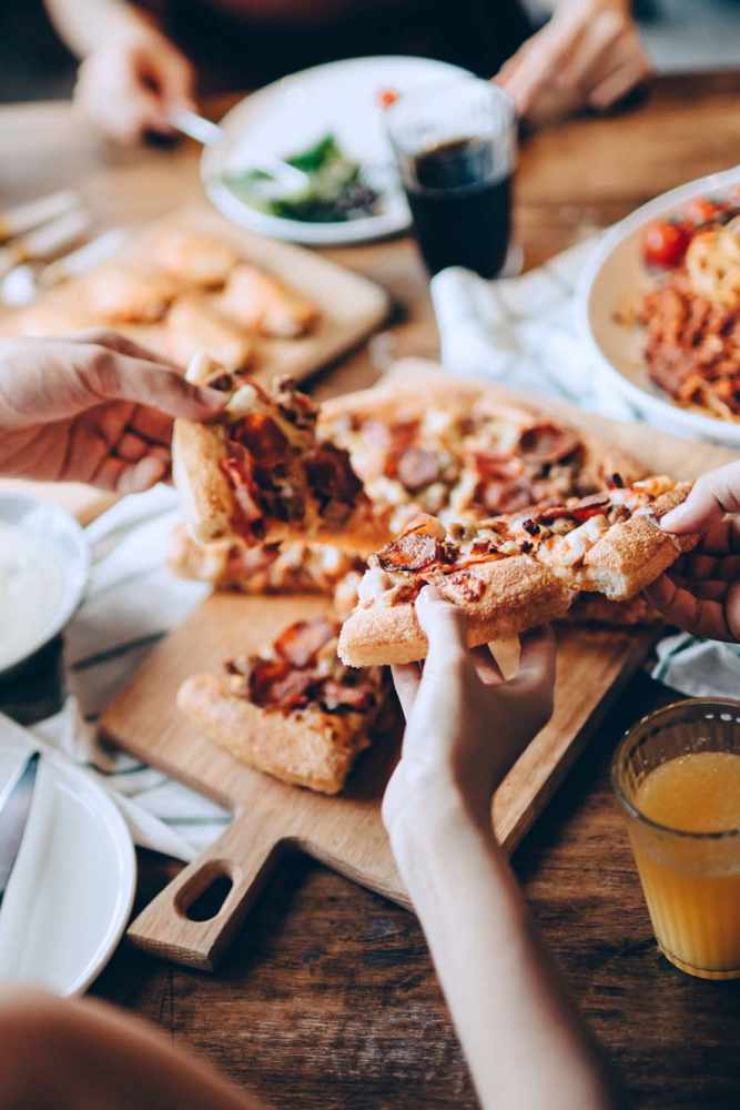 Residents having pizza at a restaurant near Arbor Park Apartments in Hurst, Texas