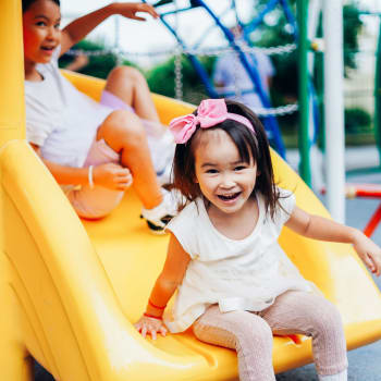 Kids going down a slide at Whitman Villa Townhomes and Apartments in Hayward, California