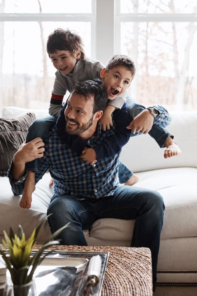 Resident family playing in their living room at Garden City/Apple Garden in Garden City, Kansas