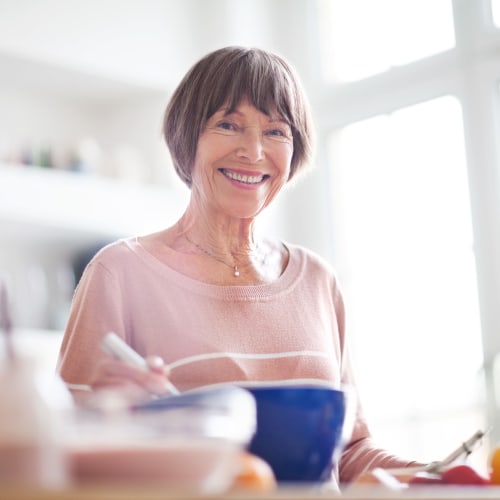 A happy resident cooking in kitchen at Sampson Road in Dahlgren, Virginia