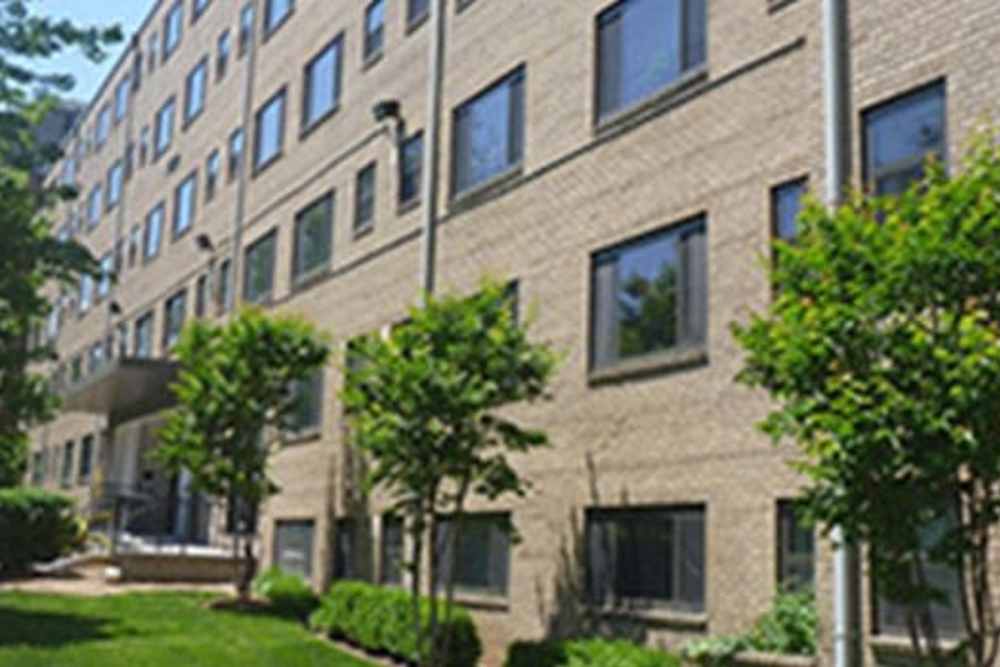 Property exterior view with trees at Franklin Apartments in Takoma Park, Maryland
