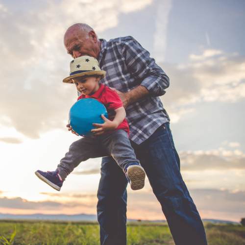 Grandfather playing with grandson outdoors near Briscoe Manor in Galena, Maryland