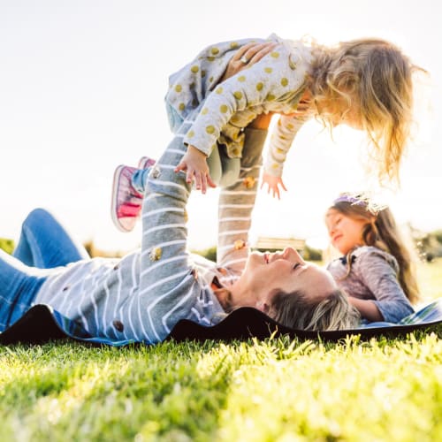 A resident playing with her children at a park near Vista Ridge in Vista, California