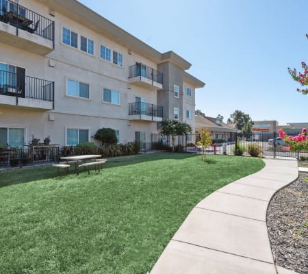Greenbelt next to building at Sunrise Residences Apartment Homes in Fairfield, California