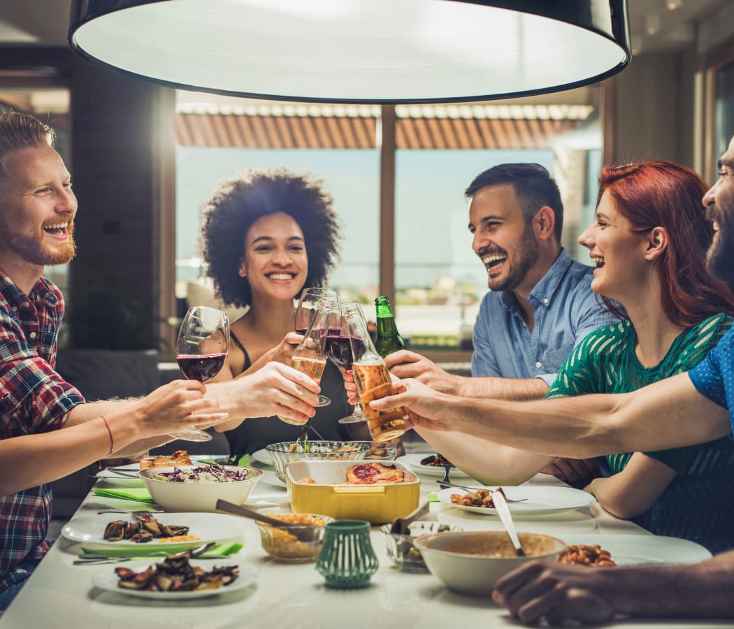 Happy friends having a dinner party at Breakwater Apartments in Santa Cruz, California