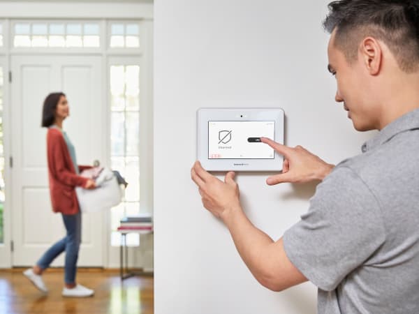 Resident couple settling an alarm in their new home at TerraLane on Cotton in Surprise, Arizona