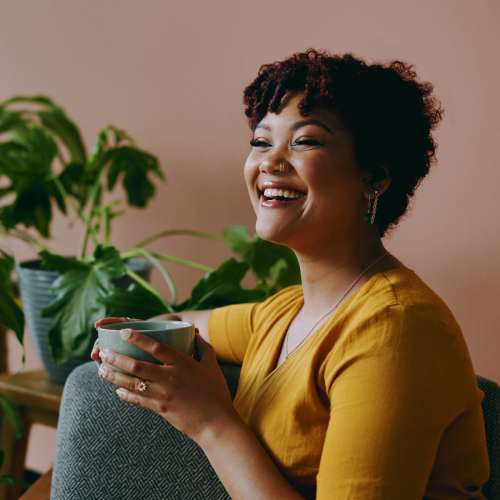 Resident woman enjoying coffee in her living room at Home Suites Apartments in Sparks, Nevada