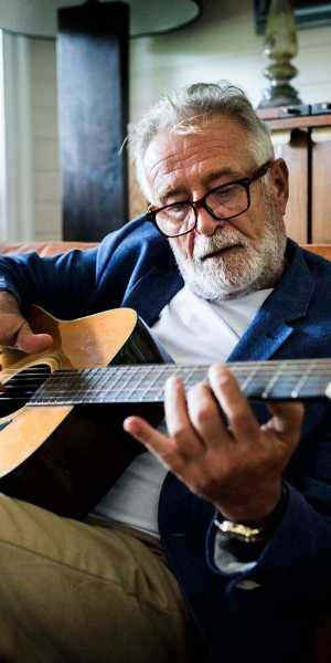 Resident playing a guitar at The Birches at New Hope in New Hope, Pennsylvania