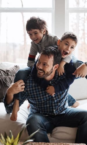 Father playing with his sons in the living room of their home at The Majestic at Hewitt in Hewitt, Texas