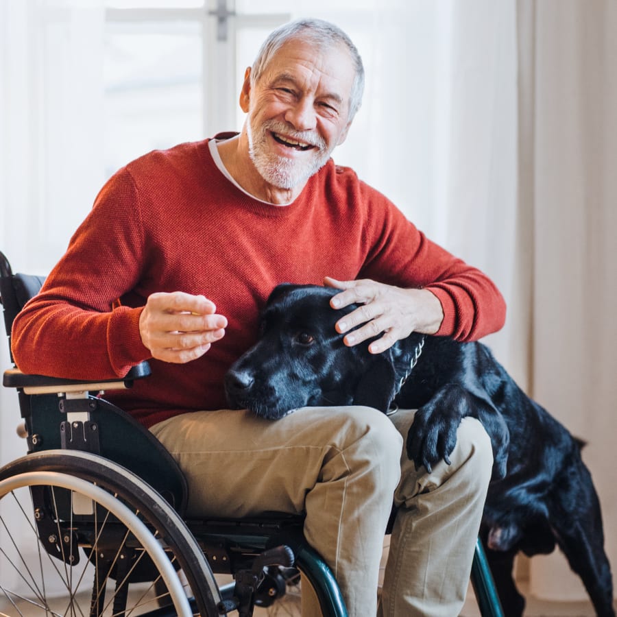 Resident on wheelchair holding his dog at Belvedere at Berewick in Charlotte, North Carolina