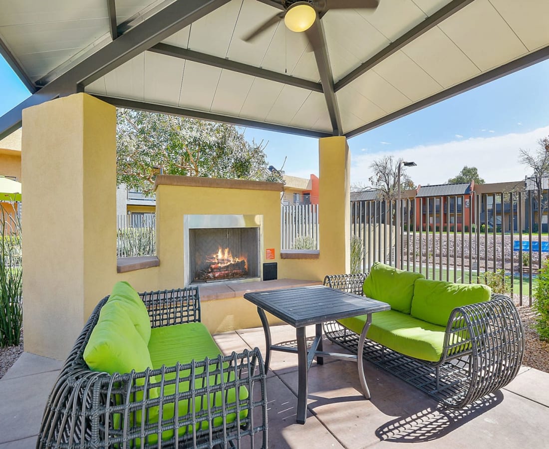 Covered outdoor lounge with a fireplace at Onnix in Tempe, Arizona