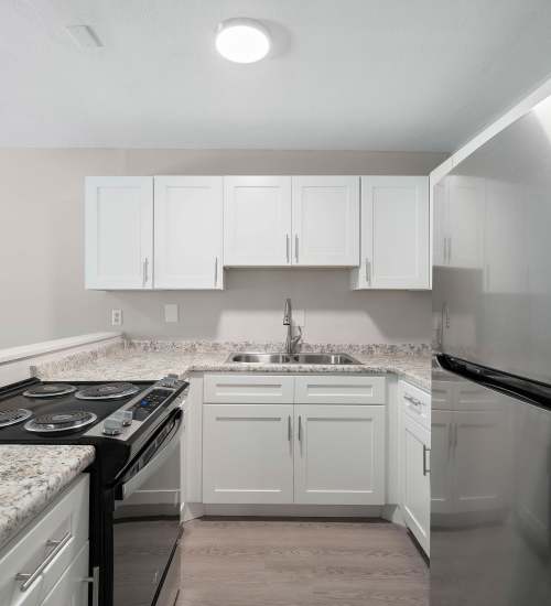 Kitchen with white cabinets and steel appliances at 216 Broadmoor in Pensacola, Florida