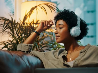 Woman wearing headphones and listening to music at Sycamore Commons Apartments in Fremont, California
