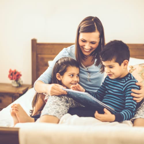 A mother reading a paper with her kids at JFSC in Norfolk, Virginia