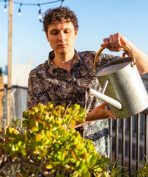 Resident watering plants at Sagewood Estates in Portland, Oregon