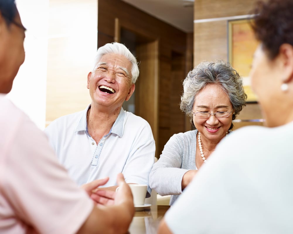 A resident couple laughing with their friends at RiverView Ridge in Rock Valley, Iowa.
