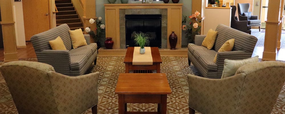 Welcoming upscale lounge seating with comfy armchairs, flowers and fireplace at The Springs at Sunnyview in Salem, Oregon