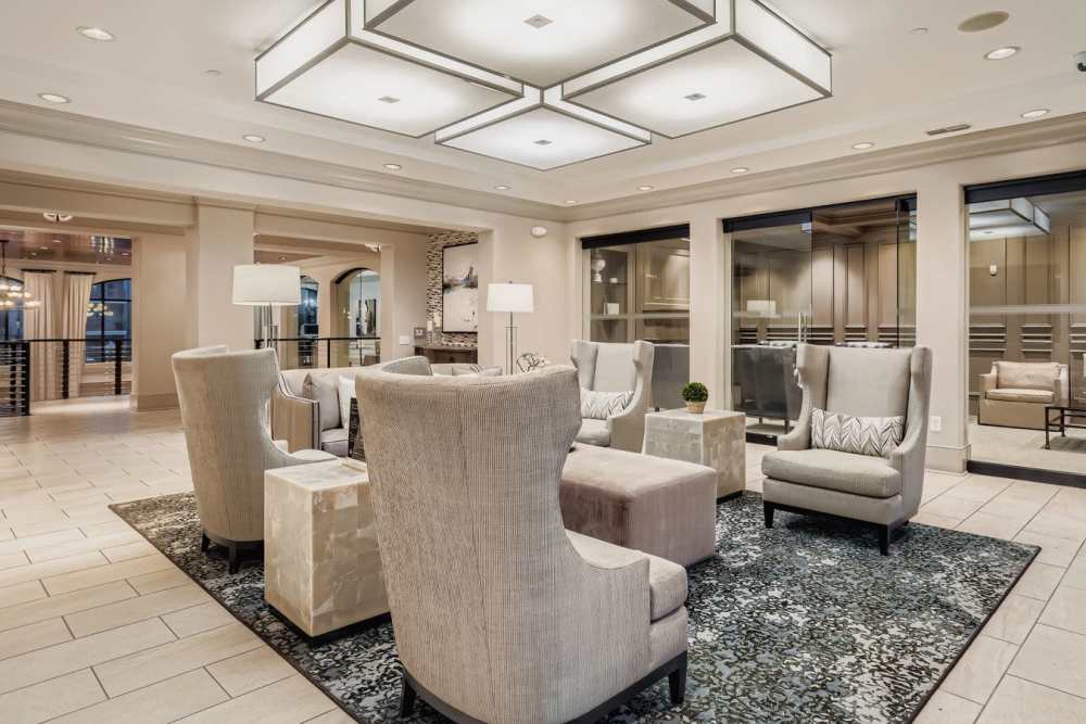 Inviting and elegant sitting area featuring stylish armchairs, a chic round coffee table, and a sleek fireplace at 2370 Main at Sugarloaf in Duluth, Georgia