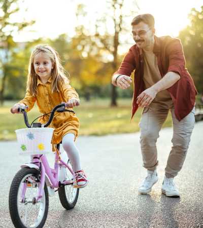 Father teaching cycling to his daughter near Gateway Park Apartments in Denver, Colorado