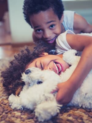 Resident kids playing with their pup in their home at The Highlands at Silverdale in Silverdale, Washington