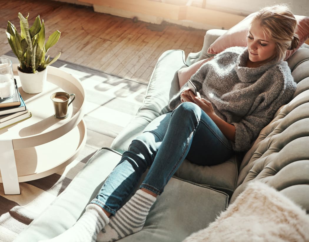 Resident relaxing on her couch at The Glens Apartments in San Jose, California