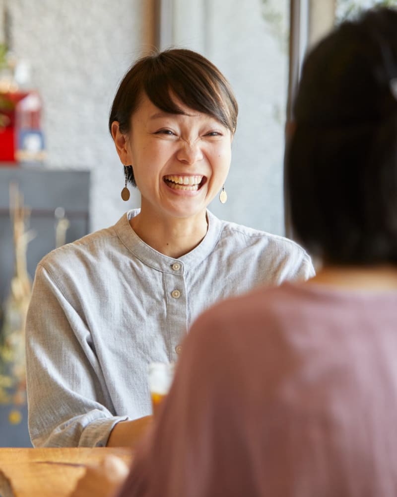 Resident laughing with a friend at a cafe near Encore at Deerhill in Clarkston, Michigan