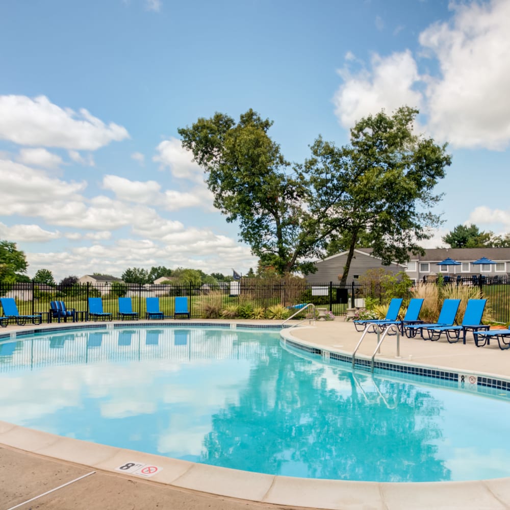 Swimming pool surrounded by lounge chairs at Montgomery Woods Townhomes in Harleysville, Pennsylvania