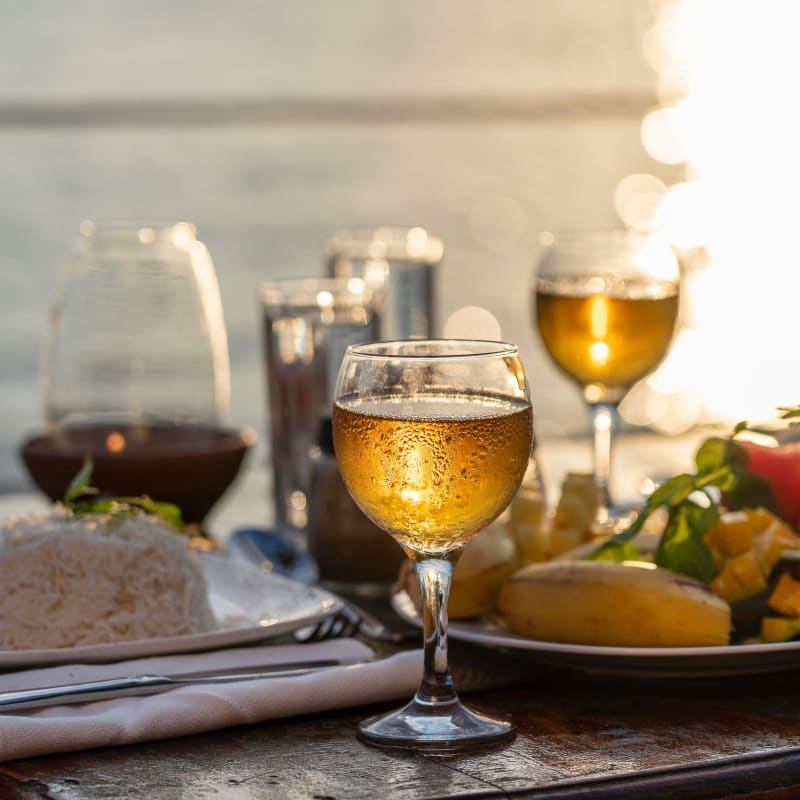 Table with a delicious meal and glasses of wine at sunset at a restaurant at Portside Ventura Harbor in Ventura, California