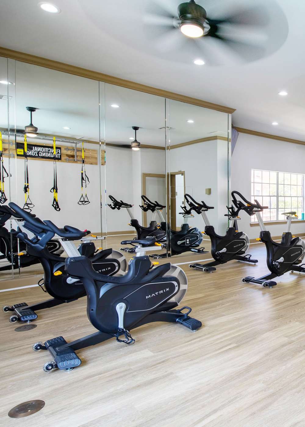 Fitness center with bike, ceiling fan and wood-style flooring at Brixton in Round Rock, Texas