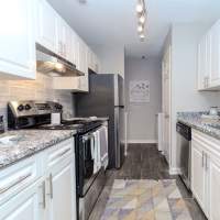 Black appliances and white cabinets in an apartment kitchen at Ten68 West in Dallas, Georgia