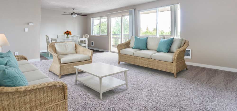 Living room and dining area with oversized windows at The Courtyard Apartment Homes in Mukilteo, Washington