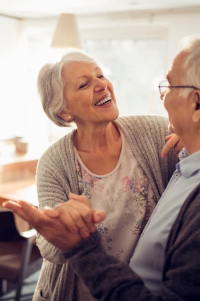 Resident couple dancing in their new apartment at a Quail Park at Morrison Ranch community