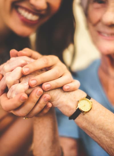 A woman holding hands with a senior at The Retreat at Canton in Canton, Georgia