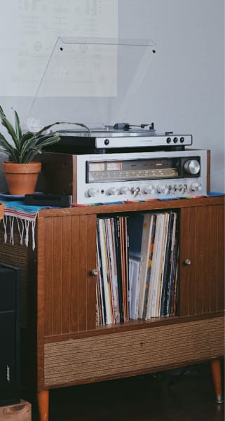 a record player sits on a shelf with records stored beneath