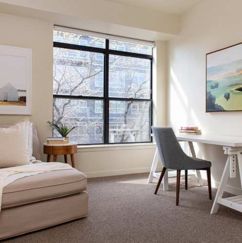 Spare bedroom with a lounge chair and desk at 1801L Apartments in Sacramento, California