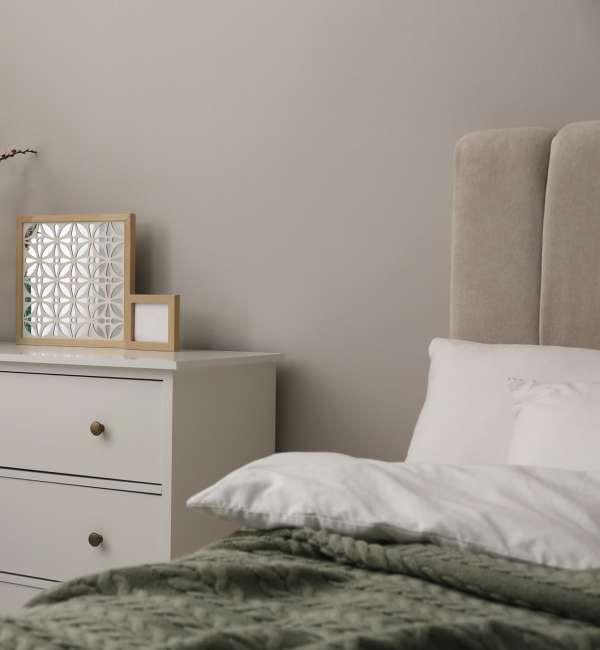 A spacious bedroom with a comfy bed and side drawer at Pecan Villa Apartments in Houston, Texas
