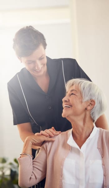 Nurse with resident hanging out both looking very happy to be where they are at Leisure Manor Apartments in Sacramento, California