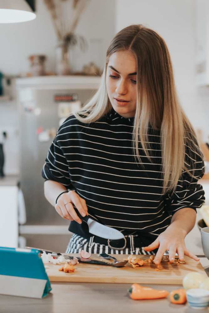 Resident dicing fresh vegetables in her modern kitchen at Filbin Creek in North Charleston, South Carolina