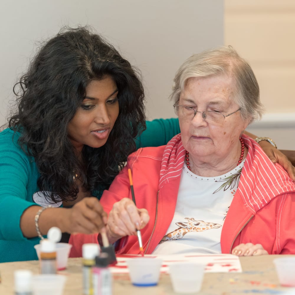 Team member and resident painting together at Inspired Living Sugar Land in Sugar Land, Texas