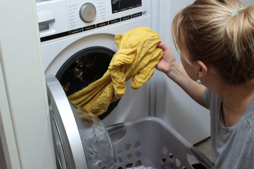 Woman using laundry facility at Cypress Point Apartments in Shawnee, Oklahoma