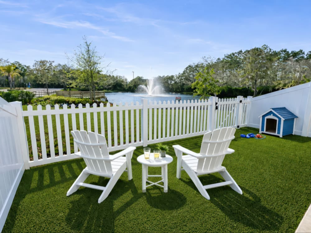 White chairs and table on green grass near Viva At Palm Coast in Palm Coast, Florida 