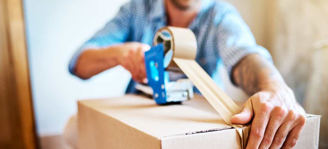 Preparing cardboard box for storage or moving at Storage Hub - Clearwater - Ulmerton in Clearwater, Florida