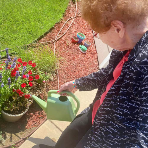 Resident watering the garden at The Oxford Grand Assisted Living & Memory Care in Wichita, Kansas