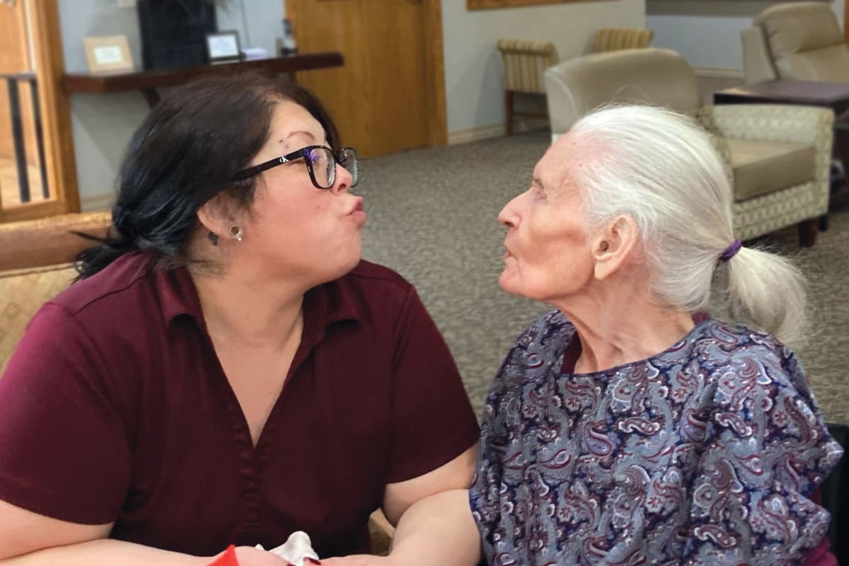 A resident and a caregiver having a nice conversation at Oxford Glen Memory Care at Sachse in Sachse, Texas 